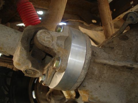 1990 Ford Bronco - Close-up view of a vehicle's driveshaft U-joint and differential housing, with a visible spacer.