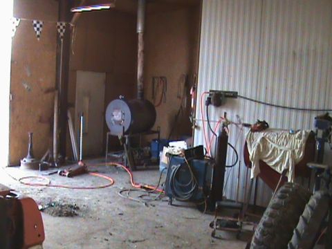 1967 Ford Bronco - A cluttered workshop scene contains a large furnace, welding gear, and a car jack on the floor.