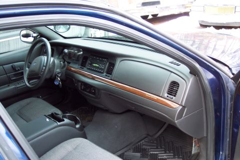 2001 Ford Crown Victoria - The interior of a blue Ford Crown Victoria, a wood-grain trim on the dashboard.