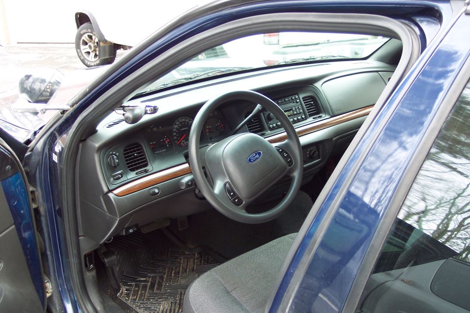 2001 Ford Crown Victoria interior showing dashboard, steering wheel with Ford logo, and driver's seat