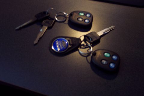 2001 Ford Crown Victoria - Car keys with remote fobs are displayed on a dark surface, one a Ford Crown Victoria emblem.