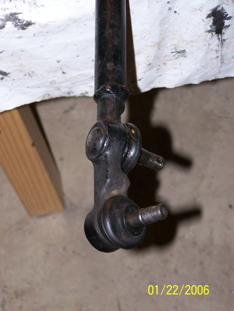 1988 Suzuki Samurai - A close-up shows a metal steering linkage component with threaded studs, likely from a vehicle's suspension system.
