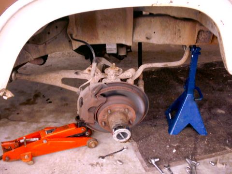 Front wheel assembly on jack stands, orange jack visible