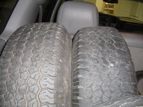 1995 Ford Bronco - Two tires are positioned inside a vehicle, with the rear seats visible in the background.