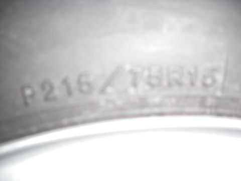 1995 Ford Bronco - Close-up of a tire sidewall displaying the size P215/75R15.