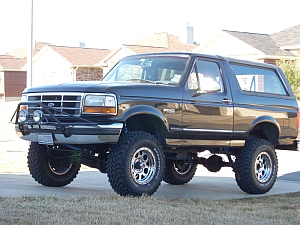 1986 Ford Bronco - This lifted Ford Bronco is shown from the front three-quarter view, parked on a paved surface.