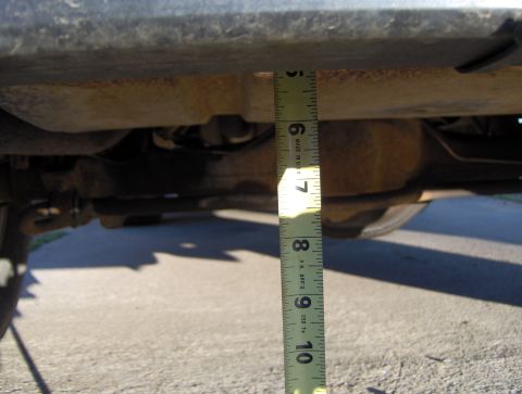 1978 Ford Bronco - A measuring tape is used to show the clearance under the vehicle's frame, indicating approximately 6 inches.