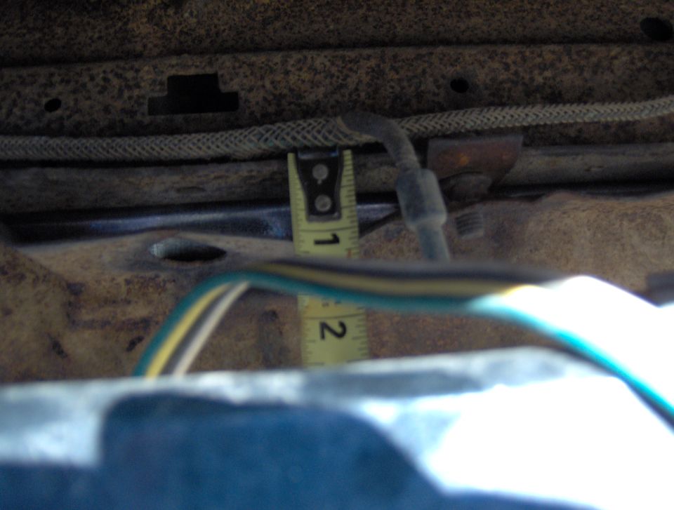 close-up of underbody with wiring and a tape measure showing about 1.5 inches