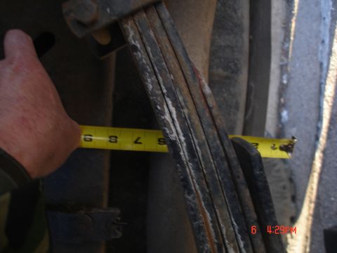 1979 Ford Bronco - A close-up shows a yellow tape measure being used to measure the vehicle's leaf springs.