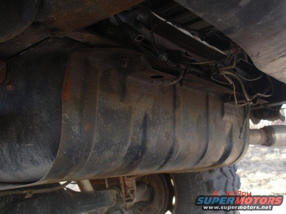 Underbody fuel tank with visible hoses and wiring