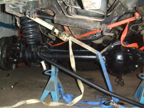 1996 Ford Bronco - The image shows the undercarriage of a vehicle, focusing on suspension components and straps, with a watermark for SuperMotors.net.