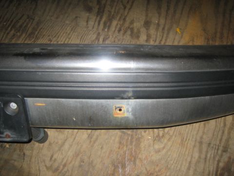 1994 Ford Bronco - A close-up view of a vehicle bumper part shows a rusty mounting hole and a small orange mark.