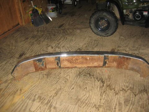 1994 Ford Bronco - A rusted bumper with chrome trim is shown on a wooden floor, with an ATV in the background.