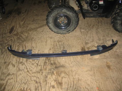 1994 Ford Bronco - A detached front bumper section rests on a wooden floor, with ATV wheels visible in the background.