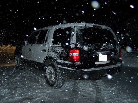 2004 Ford Expedition - A Ford Expedition is seen from the rear, covered in snow as it falls.