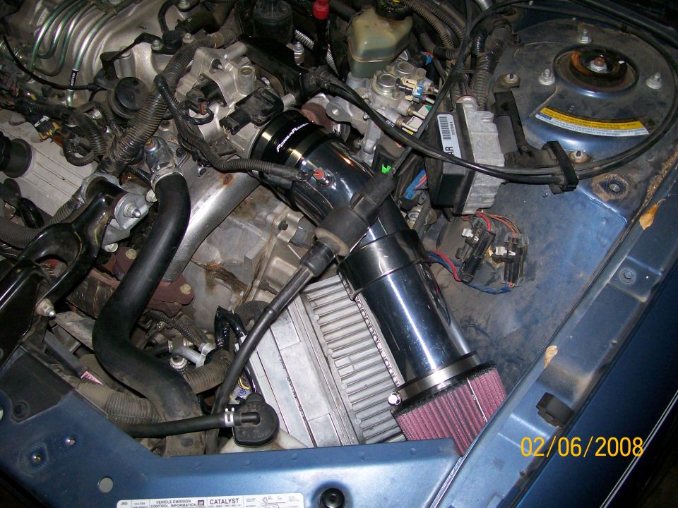 Polished aluminum cold air intake with red cone filter in a V6 engine bay