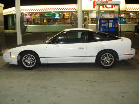 1991 Nissan 240SX - Side view of a white 1991 Nissan 240SX parked at a gas station.