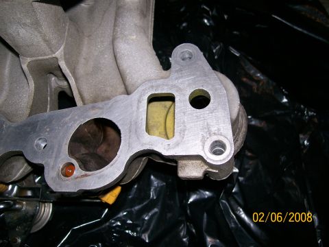 1995 Mercury Grand Marquis - This is a close-up view of an intake manifold gasket, showing its metal construction and a yellow gasket material.