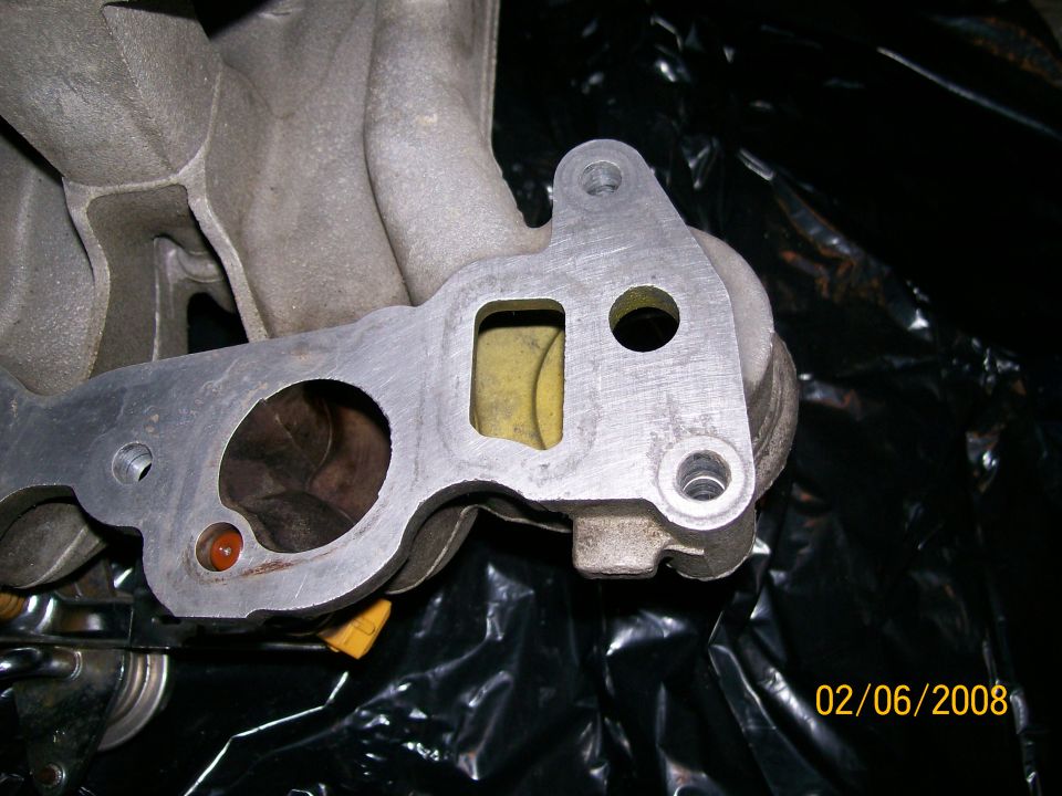 Close-up of an intake manifold gasket with yellow material visible through a rectangular opening