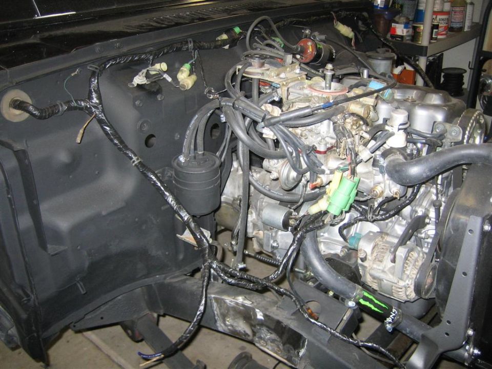 Engine bay wiring harness with carburetor and distributor visible