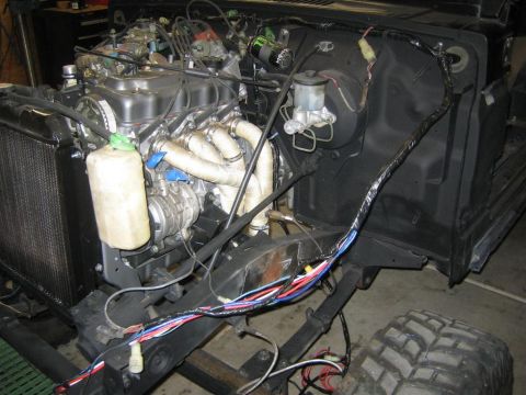 1987 Suzuki Samurai - Vehicle engine bay showing the engine, radiator, and a complex wiring harness.