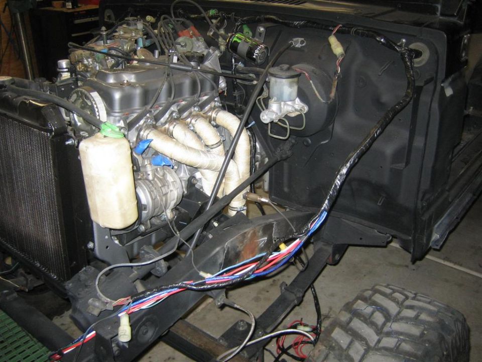 Engine bay of a vehicle with exposed wiring harness and exhaust manifold