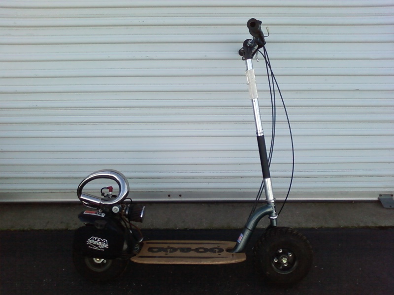 Motorized scooter with knobby tires and a chrome exhaust pipe