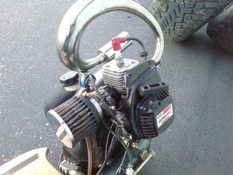 1995 Ford Bronco - A small engine with a chrome exhaust pipe and air filter is shown close-up.