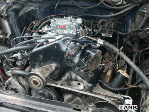 1984 Ford Bronco - Close-up view of a vehicle's engine bay, showing the carburetor and associated components.