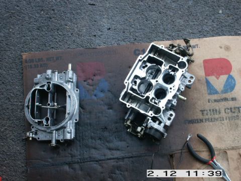 1984 Ford Bronco - Two carburetors are laid out on a cardboard box, with a pair of wire cutters nearby.