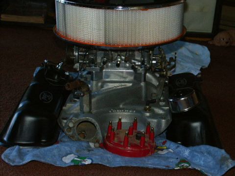 1984 Ford Bronco - Engine block with air filter, carburetor, and distributor cap rests on a blue cloth.