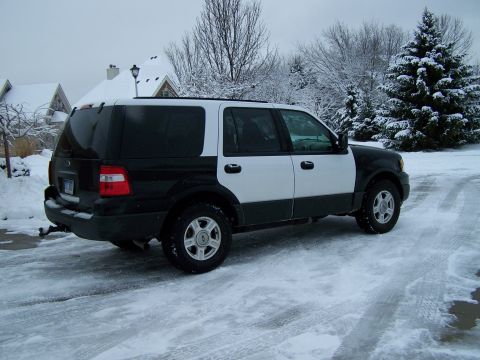 2004 Ford Expedition - A two-tone black and white SUV is parked on a snow-covered road during winter.