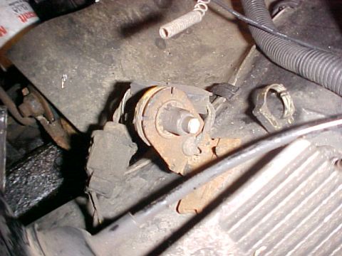1979 Ford LTD - This image shows a close-up view of a rusty mechanical component within an engine bay, wires and a coiled spring.