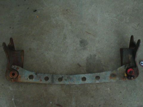 1989 Ford Bronco - This is a rusted metal bracket with multiple circular holes and mounting points.