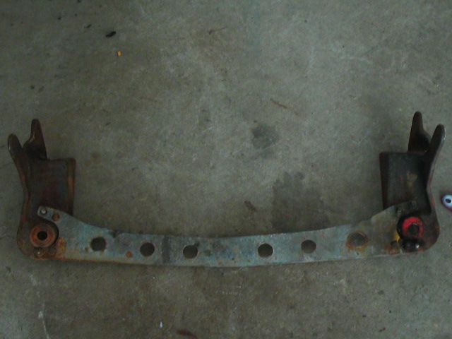 rusted metal bracket with circular holes and mounting points