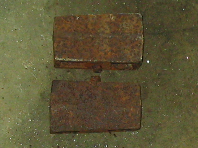 Two rusty rectangular metal parts with mounting tabs