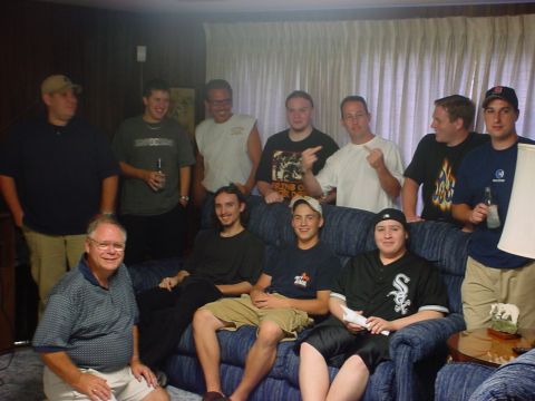 1985 Ford LTD Crown Victoria - A group of men are gathered in a room, with some sitting on a couch and others standing behind them.