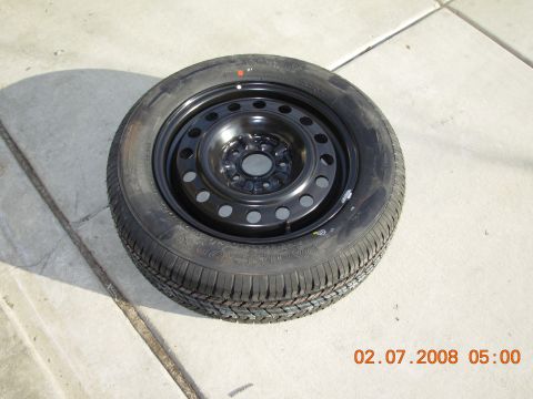 1995 Ford Taurus - A spare tire is shown resting on a concrete surface.
