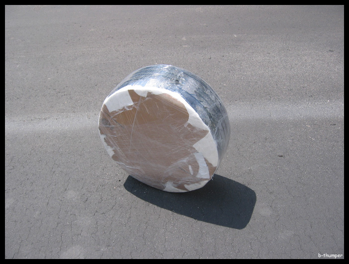 Tire wrapped in plastic and tape on asphalt
