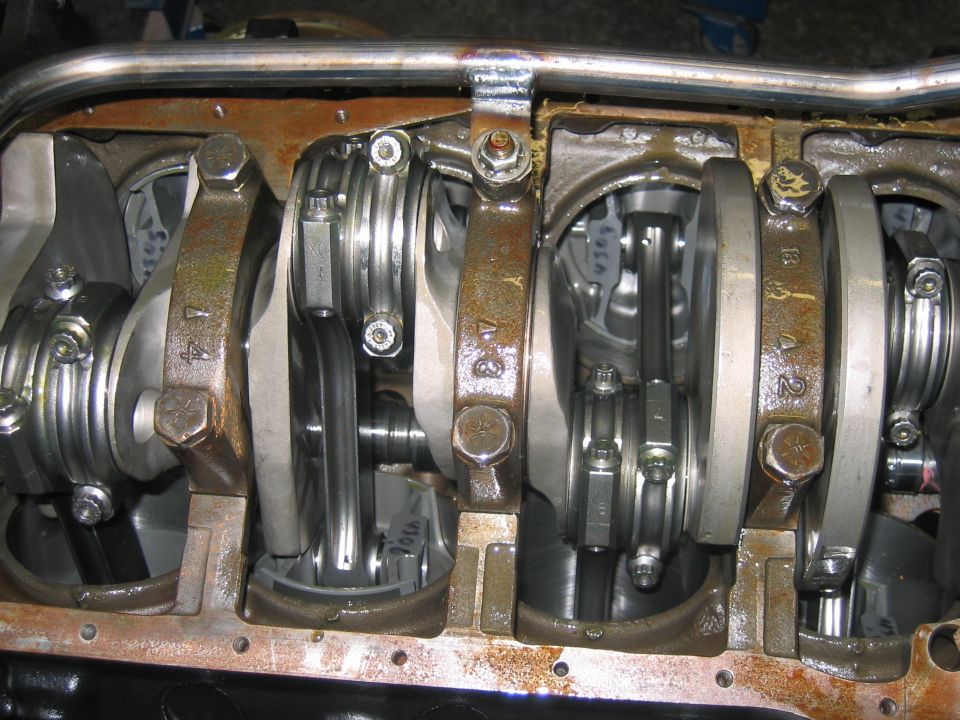 Engine block with crankshaft and connecting rods visible. Some rods have stamped numbers like '1A', 'B3', 'A2'