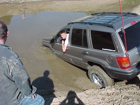 1999 Jeep Grand Cherokee - Jeep Grand Cherokee stuck in mud, driver looking out window.