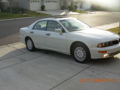 1995 Ford Taurus - A white sedan is parked in a suburban driveway with garages in the background.