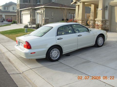 1995 Ford Taurus - A white sedan is parked in a suburban driveway on a sunny day.