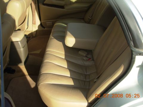 1995 Ford Taurus - The interior of a car shows tan leather seats and a center console with a date stamp in the corner.