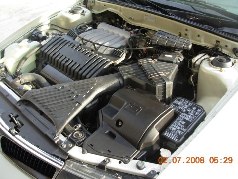 1995 Ford Taurus - The engine bay of a vehicle, a V6 engine cover and a visible fuse box with text. A date stamp indicates 02.07.2008.