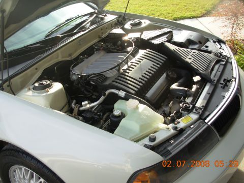1995 Ford Taurus - The engine bay of a car is shown with the hood open, revealing the engine and various components.