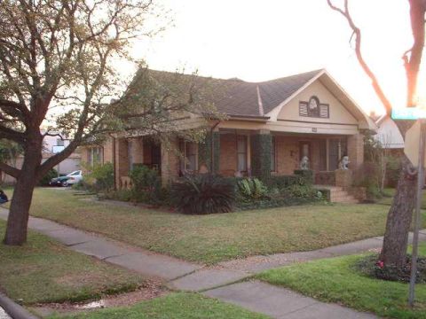 1996 Ford Taurus - A house with a porch and a large tree in the yard, with a car visible in the background.