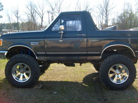 1989 Ford Bronco - Side profile of a lifted 1989 Ford Bronco with custom wheels and tires.