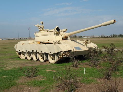 1997 Ford Crown Victoria - A military tank is parked in an open field under a clear blue sky.