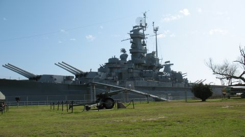 1997 Ford Crown Victoria - Battleship USS North Carolina on display with a field cannon in front.